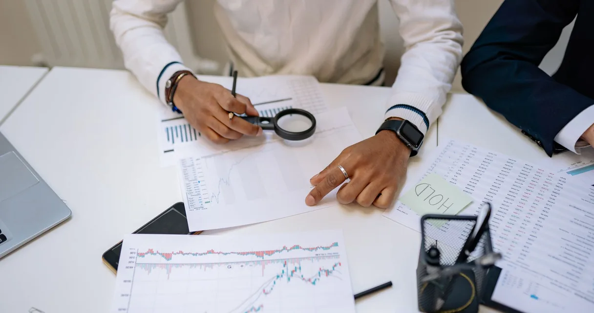 Consultor financeiro analisando documentos e uma calculadora sobre a mesa