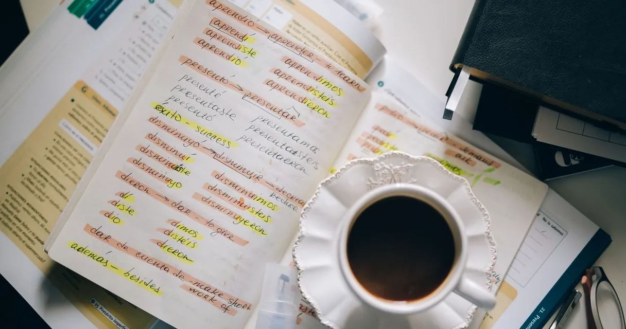 Mesa de estudos com livros, caderno e notebook para aprendizado de idiomas