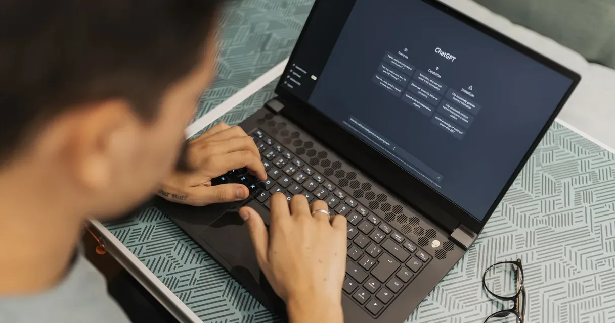 Pessoa digitando uma pergunta no ChatGPT em um notebook